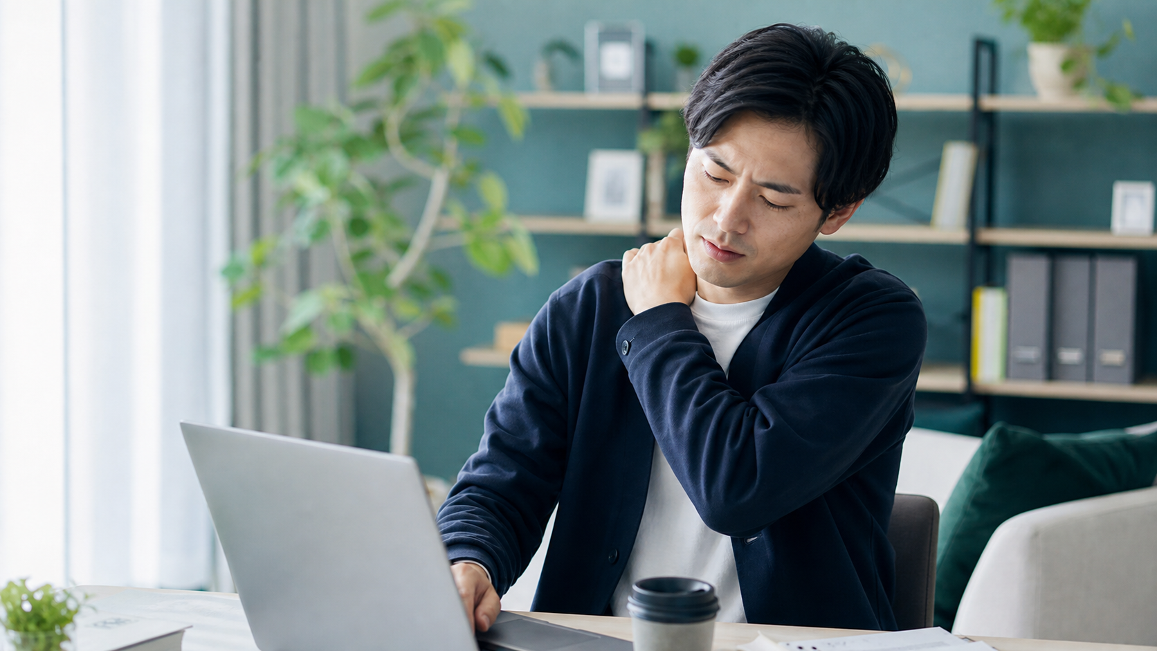 デスクワークで肩の不調を感じるパパのイメージ